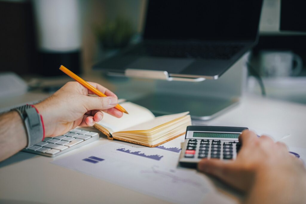 Księgowy liczący w notesie oraz używający kalkulatora